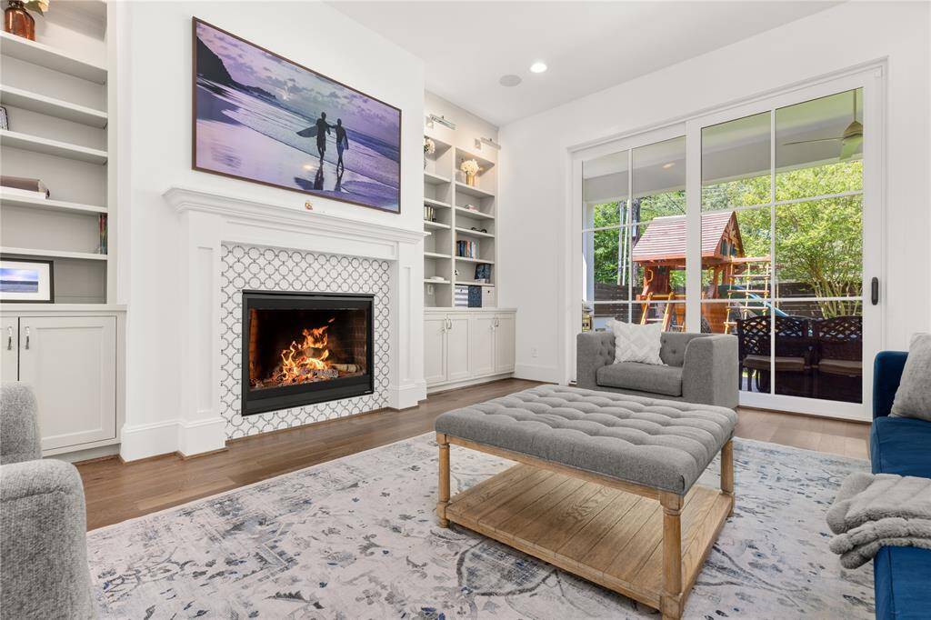 Gas fireplace, built-in entertainment center w/ shelving, cabinets, & lighting; Sliding doors to outdoor kitchen.