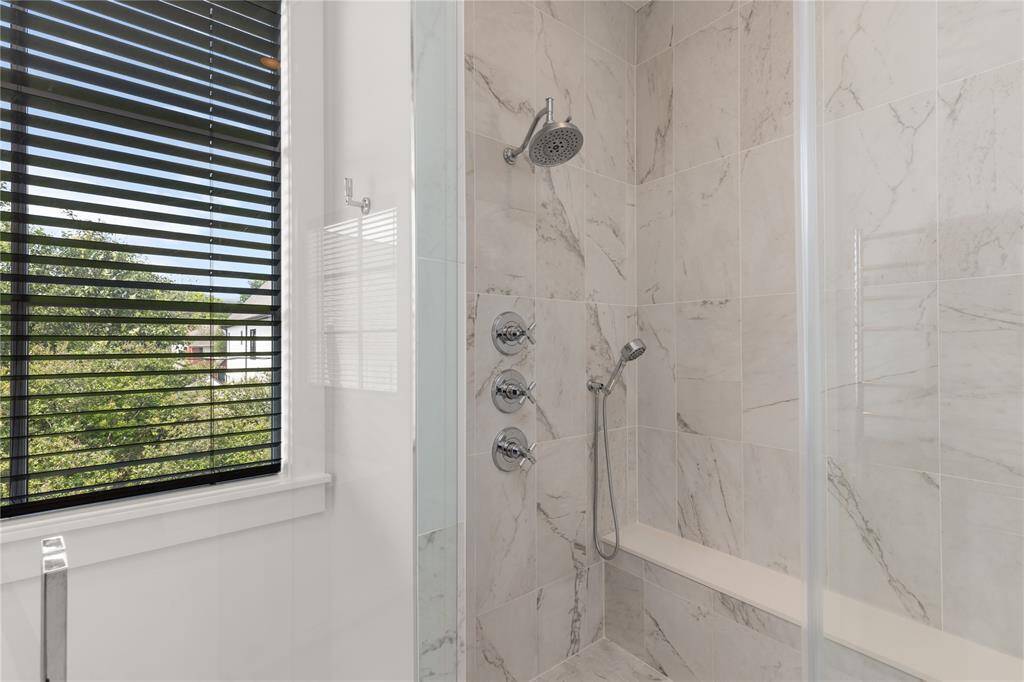 Chrome shower head, rain shower head & hand held shower head; Wall Towel Warmer just outside shower.