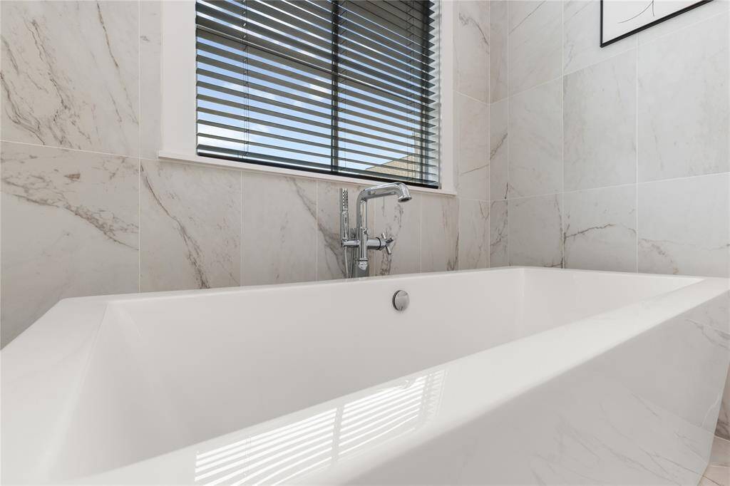 Freestanding soaker tub w/ chrome faucet & hand held attachment for convenience.