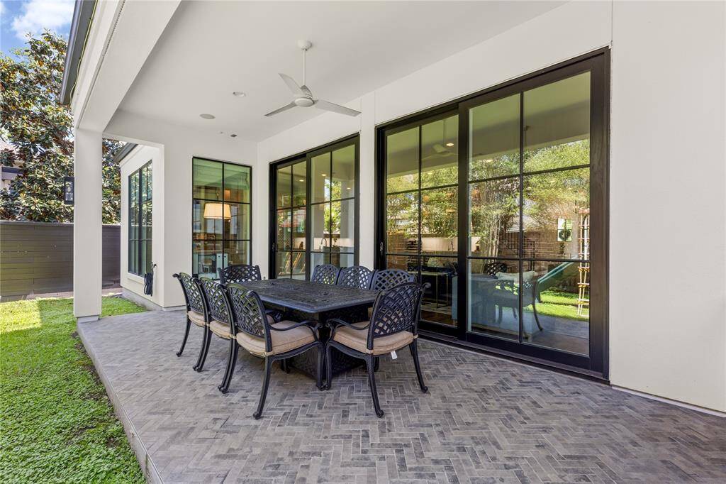 Herringbone brick patio w/ recessed lighting, sliding doors, ceiling fan.