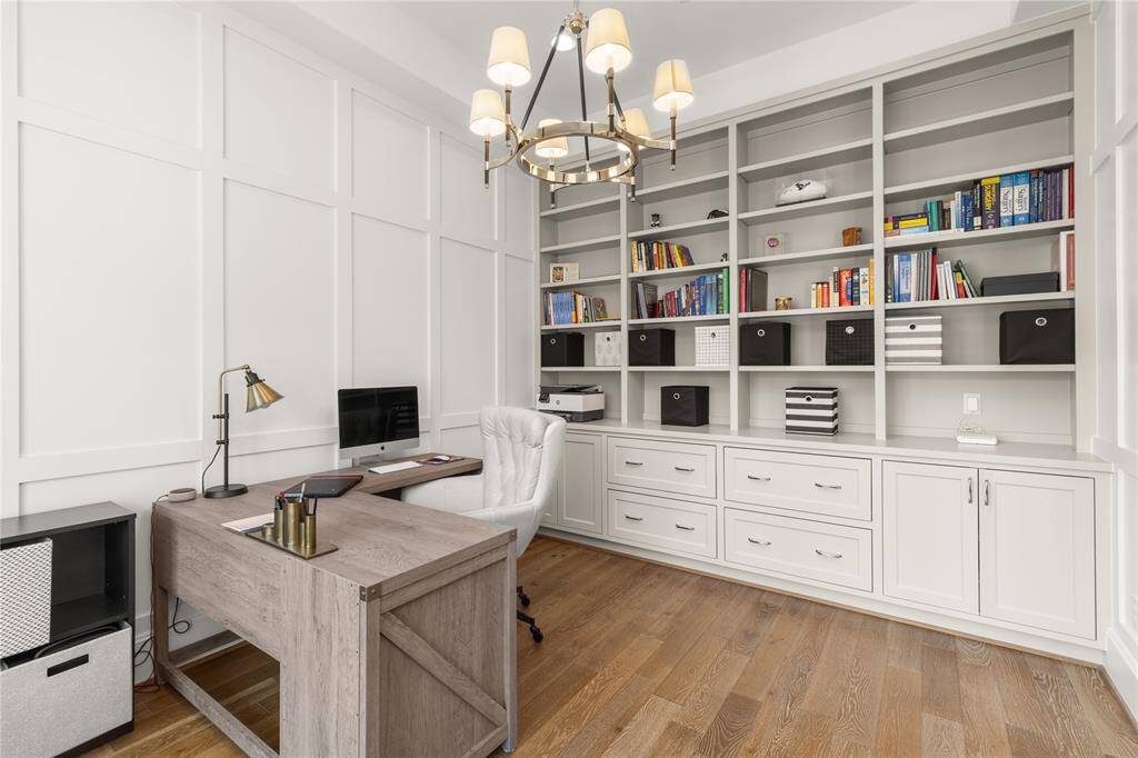 Private study with accent paneled walls w/ custom cabinetry