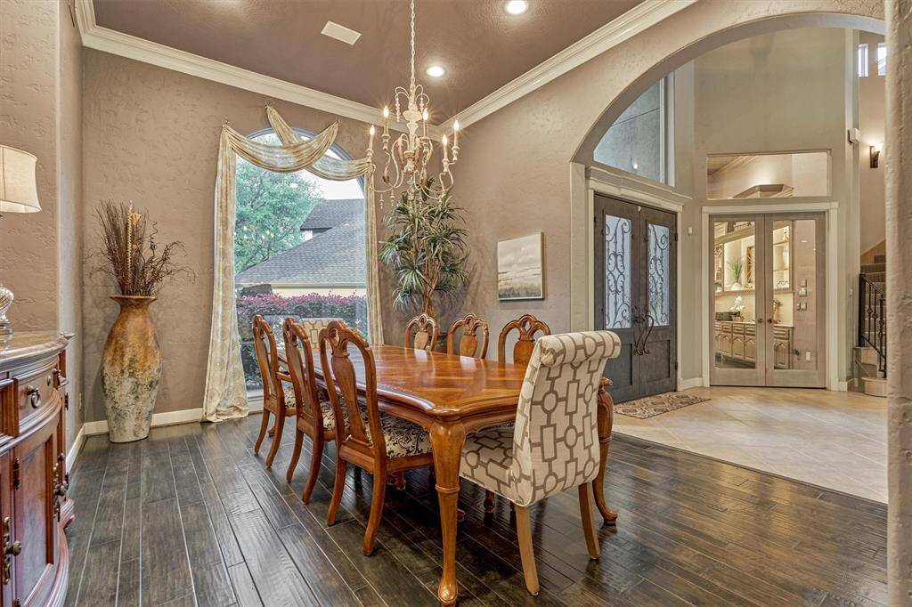 Crown molding continues into the elegant formal dining room, which offers ample space for a large dining table and features a stylish niche perfect for a buffet or sideboard.