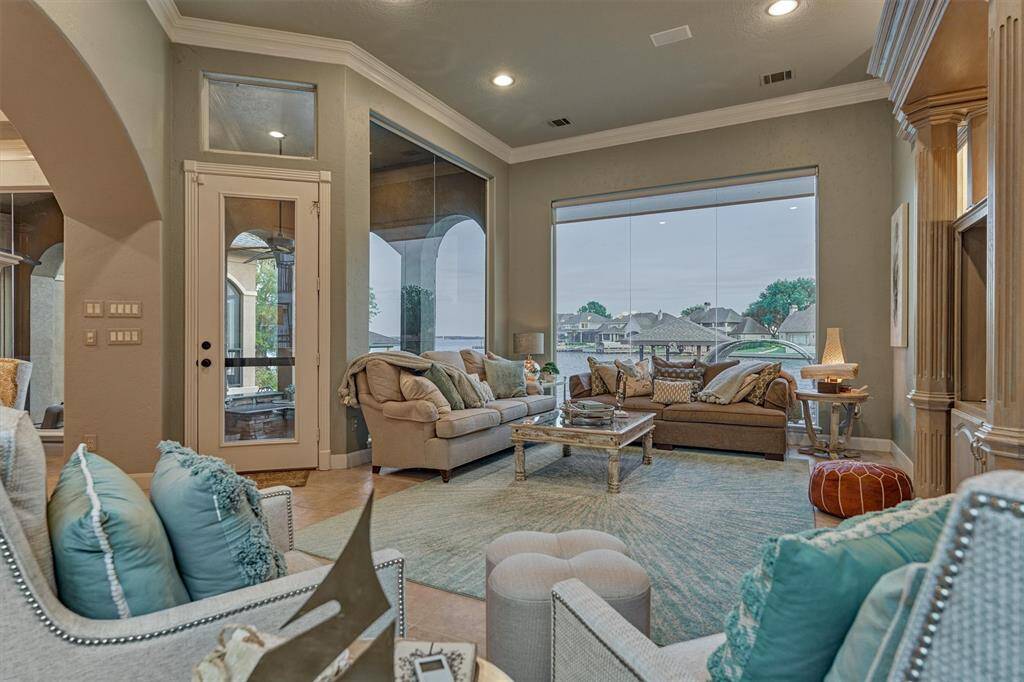 This angle showcases the expansive windows designed to maximize lake views. A glass door leads directly to the back porch, outdoor kitchen, and pool area—seamlessly blending indoor comfort with effortless outdoor living.