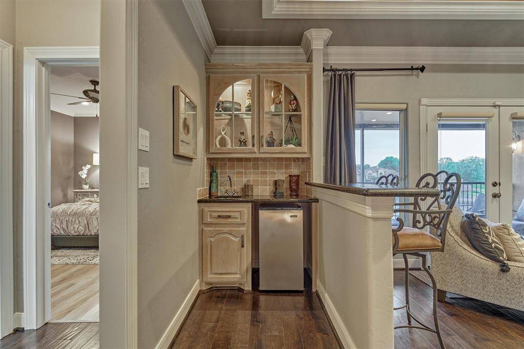 The game room’s bar area is thoughtfully designed with a beverage refrigerator, sink, and storage for snacks, along with a convenient snack bar- ideal for casual entertaining and laid-back gatherings.