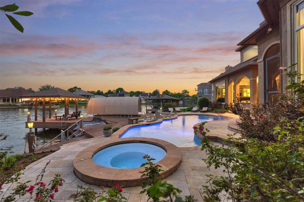 The backyard transforms into a serene and inviting retreat at night, with soft lighting that enhances the peaceful ambiance and highlights the beauty of the lakefront setting.