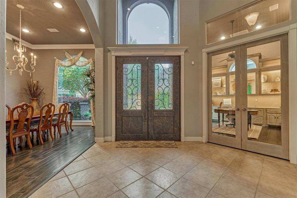 The double door entry is framed by custom molding, creating an elegant first impression. Just off the entry, double glass doors open to a private office, while a formal dining room provides a dedicated space for entertaining.