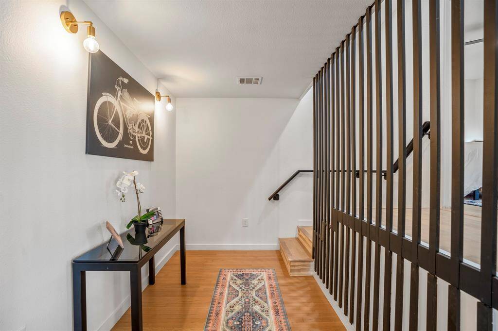 This hallway leading you to the primary bedroom with sconce lighting is the perfect area for small tables for decor and artwork.