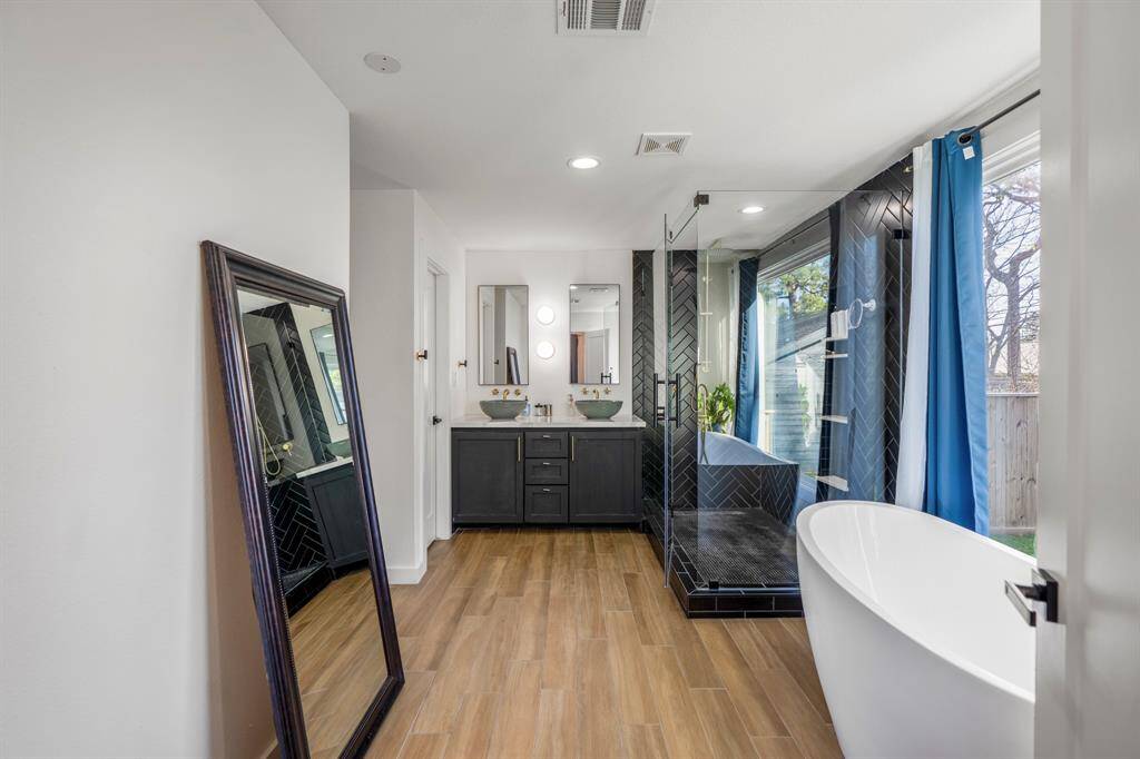 Welcome inside your adorable primary bathroom with a separate soaking tub overlooking your tranquil backyard space.