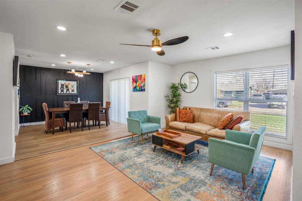 A zoomed out look at this open-concept floor plan with the living room seamlessly flowing into the formal dining room. Notice a new ceiling fan in this space for maximum comfort.