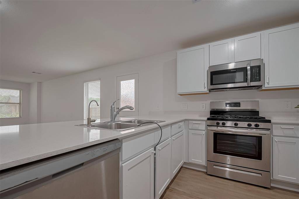 The well-planned kitchen maximizes both storage and workspace, with ample cabinetry and generous countertops. The area is open to the dining and living spaces, ensuring effortless interaction while cooking or entertaining.