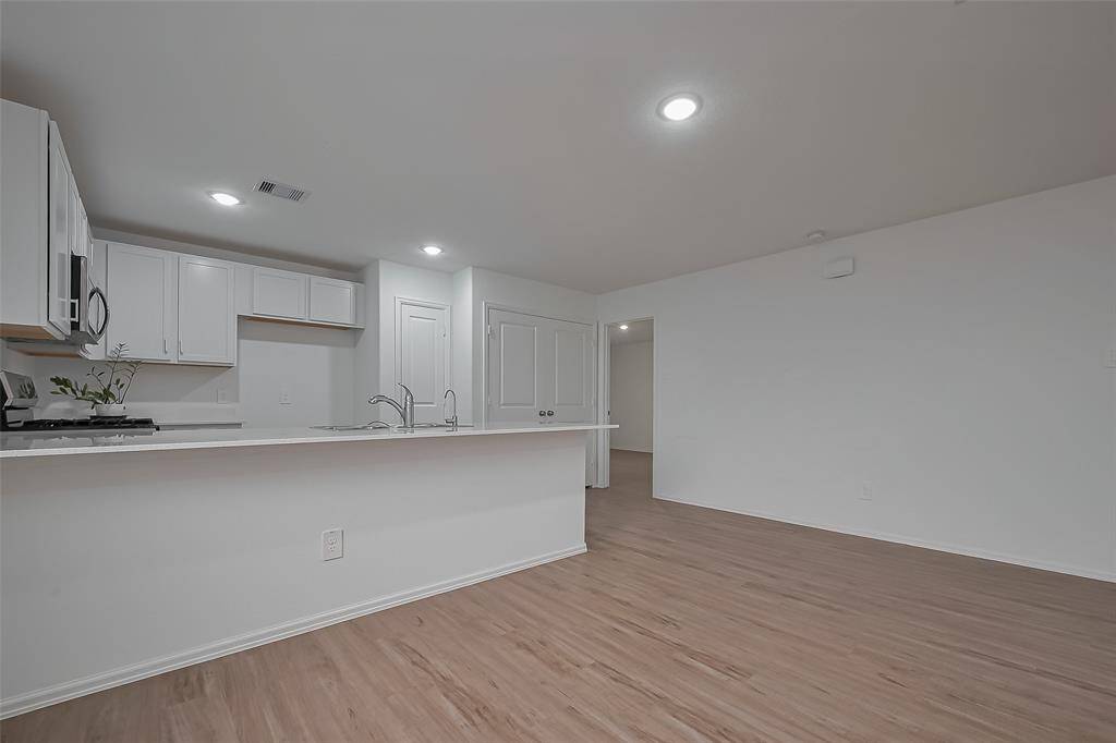 The kitchen and dining area combine efficiency with charm. A glass-paneled door leads outside, bringing in natural light and offering easy backyard access.