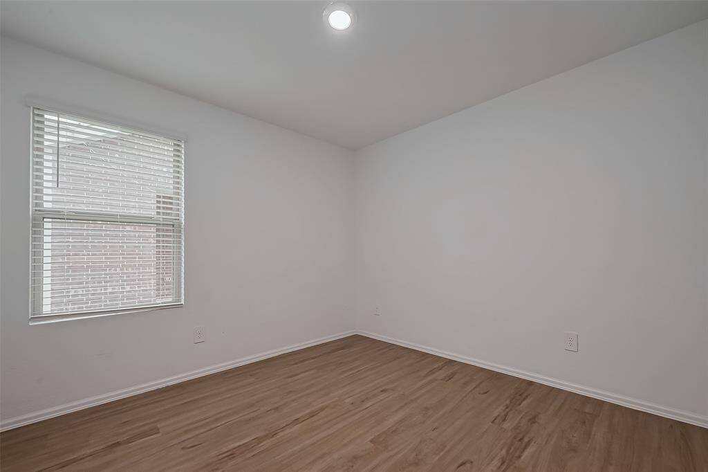 Expansive and versatile, the primary bedroom provides ample space for a large bed with additional furnishings. Whether incorporating a sitting area, a workspace, or statement décor, the open layout can accommodate various design choices. The recessed lighting enhances the natural brightness from the windows, creating a well-balanced atmosphere.