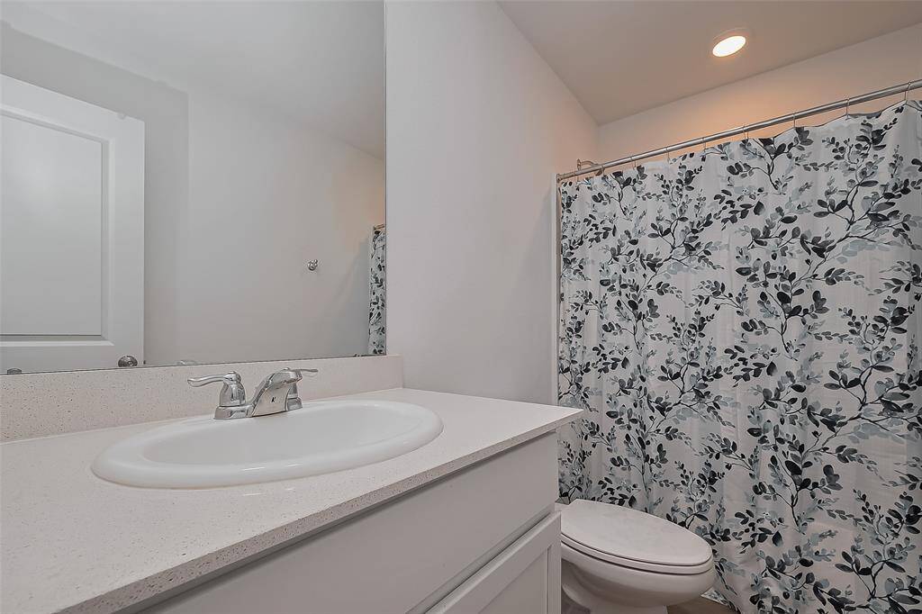 Designed with comfort in mind, this primary bathroom offers a balance of space and efficiency. The extended countertop, under-cabinet storage, and large mirror create a well-organized and practical setup. The shower-tub combo provides options for both quick refreshes and leisurely soaks.