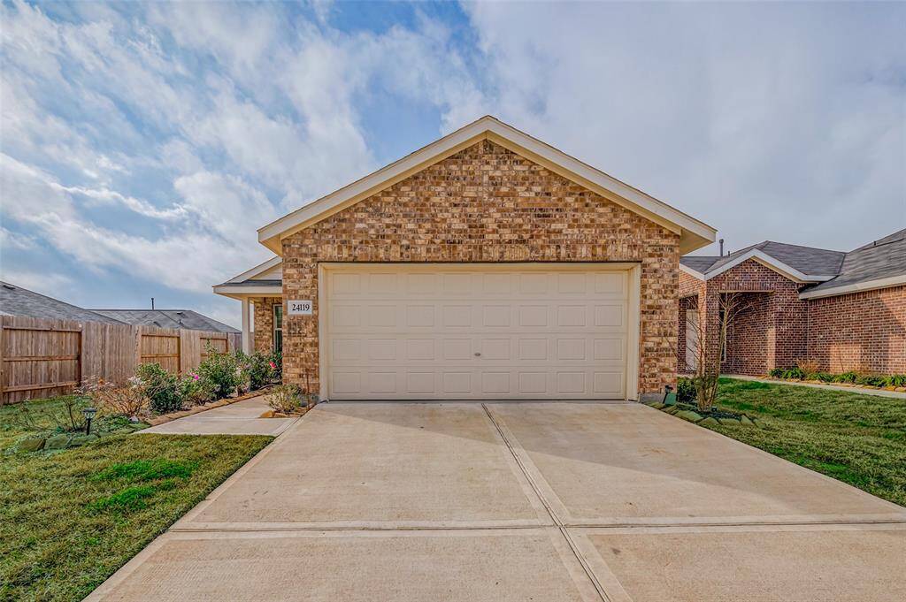 A classic brick exterior sets the tone for this charming home, with a neatly paved driveway leading to the entrance. The manicured lawn on either side adds a fresh, welcoming touch, while a thoughtfully arranged flower bed enhances the walkway with pops of color.