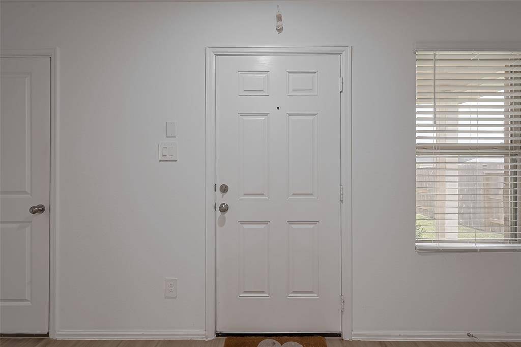 Step inside to a bright and airy entryway that immediately opens to the heart of the home. Soft natural light filters in, complementing the crisp walls and warm flooring.