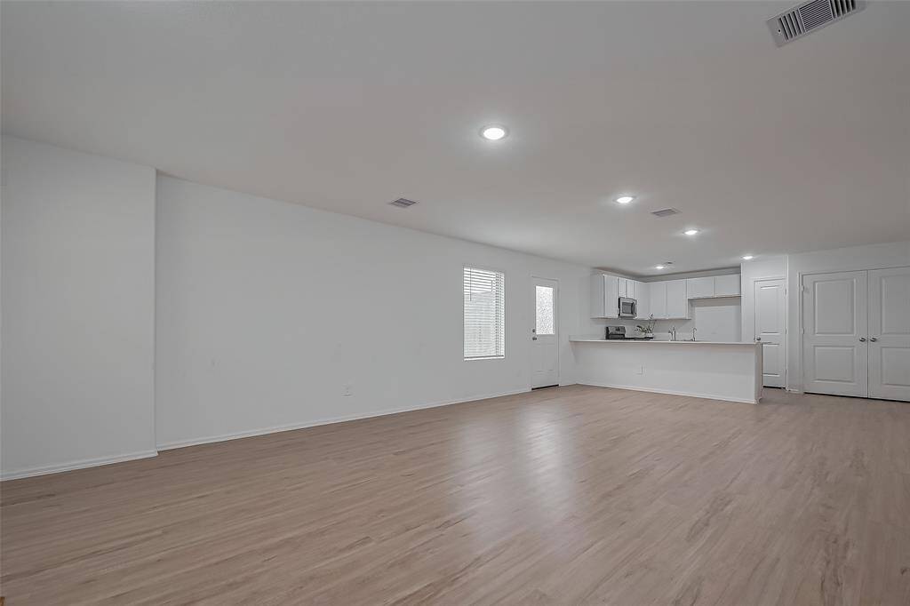 From the front door, the view extends toward the spacious living area and kitchen, creating a seamless flow that makes the space feel even larger.