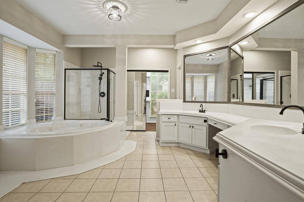 The master bath is spacious with updates that includes new cabinet faces, all new fixtures on the sinks and in the shower.