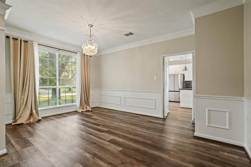 This dining room is accompanied by a vintage chandelier, and custom woodwork as well as a huge window that allows amazing natural light.