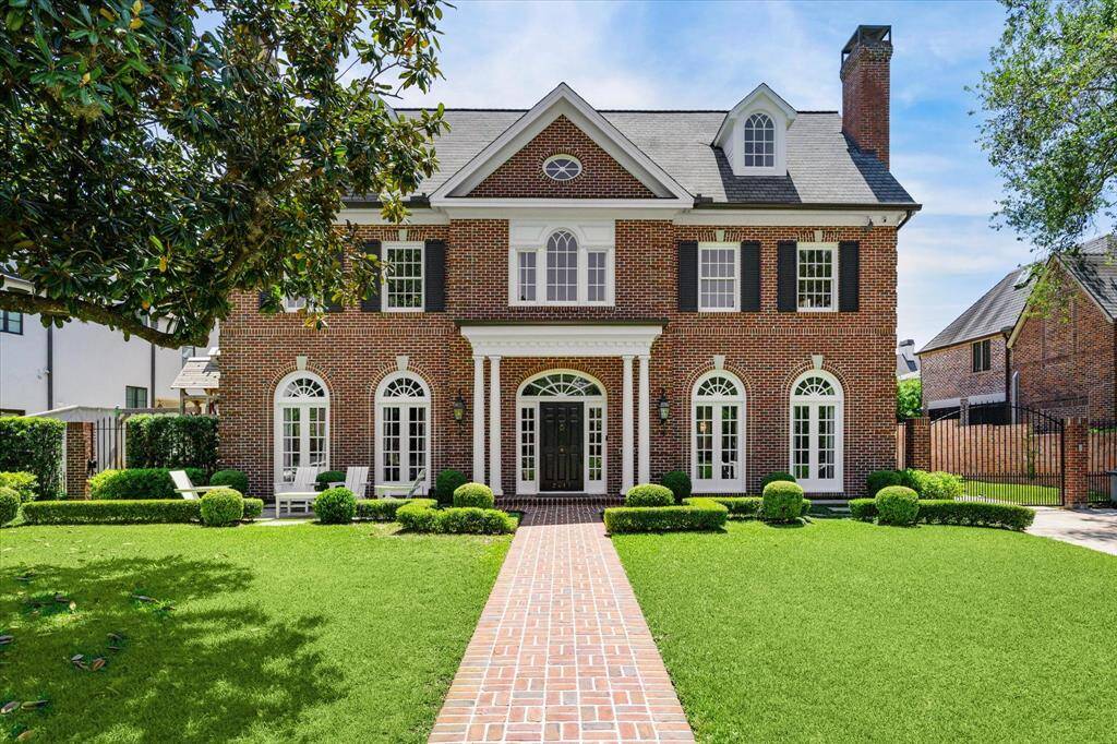 Step into timeless elegance with this beautifully renovated all brick River Oaks property. This home promises luxury living, with its charming symmetry and ample lush green lawn perfect for sunlit afternoons. Note the lovely seating area on the left.