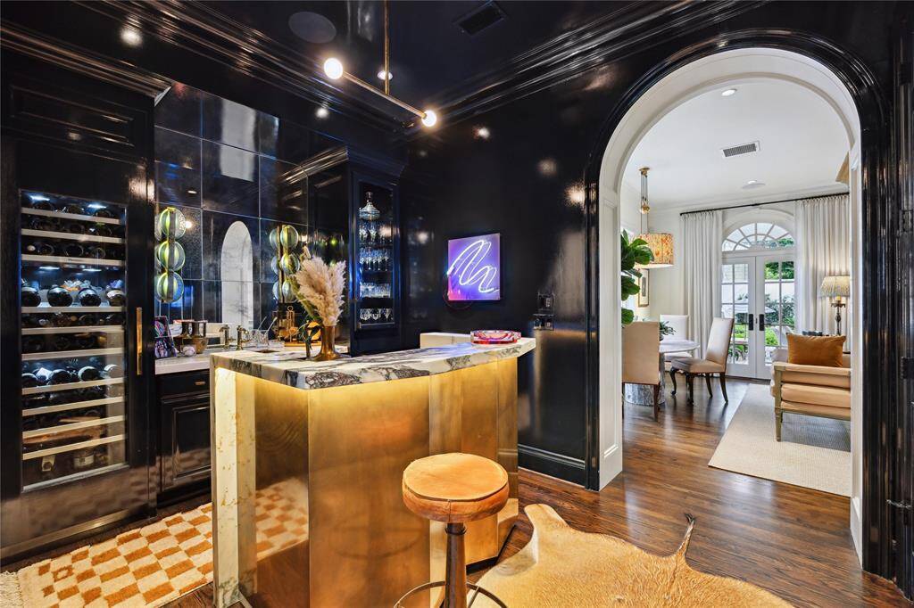 A striking Home Bar exudes Farrow and Ball’s high gloss lacquer known as Black Blue, Thermador wine storage and opens elegantly into the Family Room.