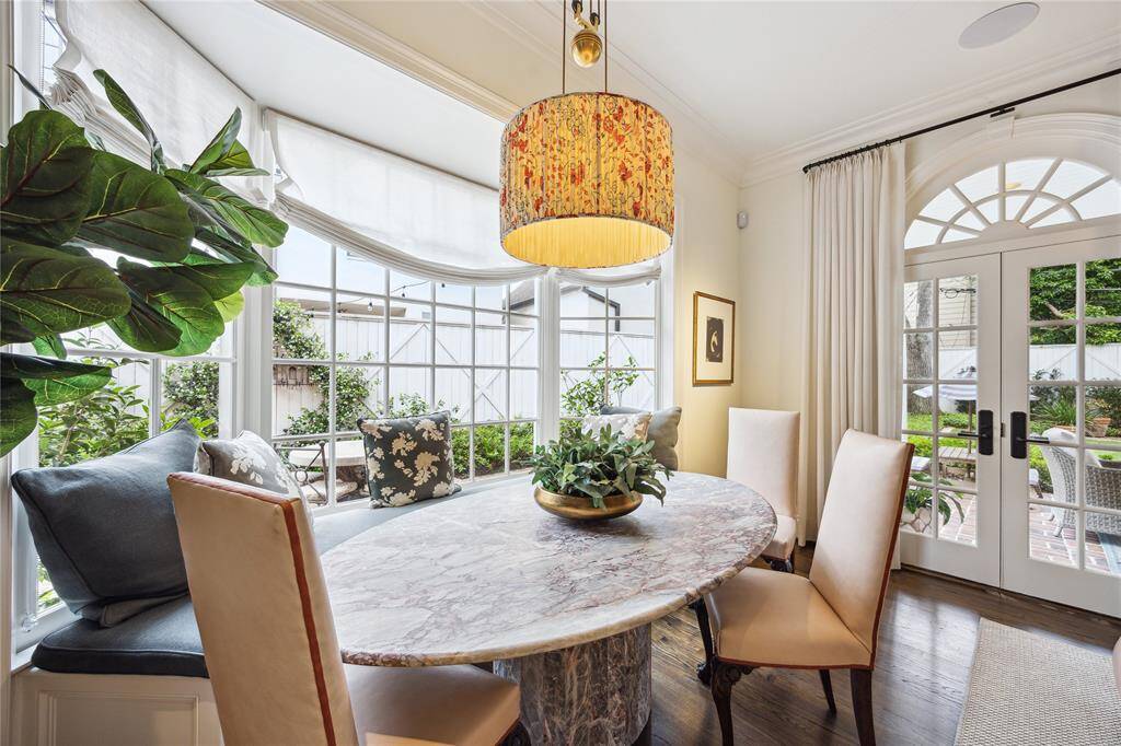 The charming Seating Area within the Family Room includes a cozy window bench framed by expansive windows and French doors, welcoming abundant natural light and picturesque outdoor views.