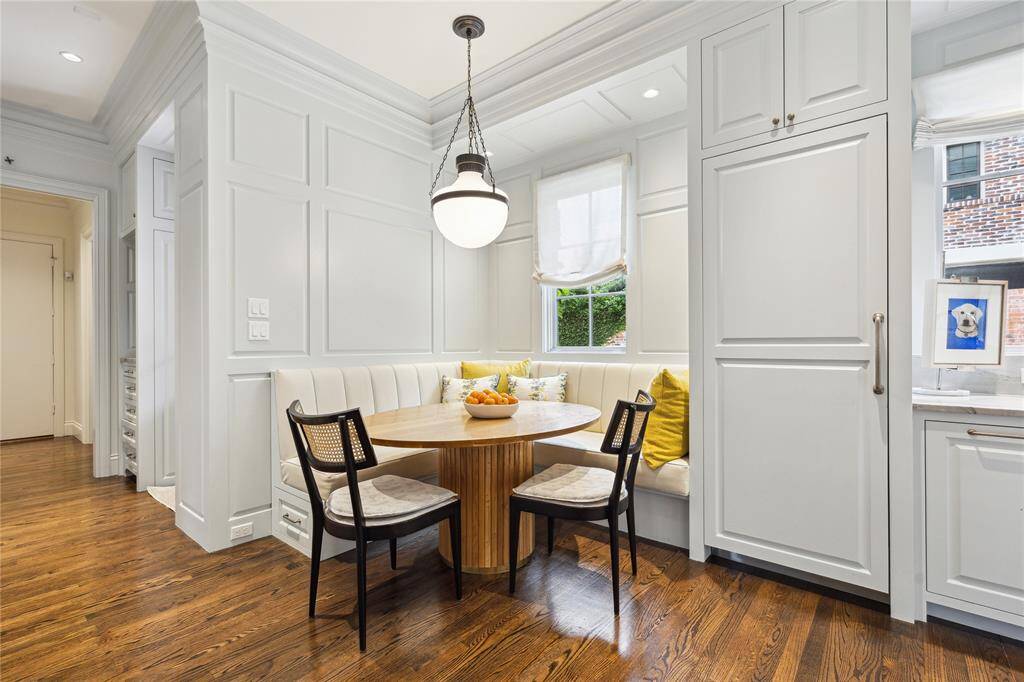 This cozy Breakfast Nook features a custom-designed banquette upholstered in durable vinyl, a roman shade, and wainscoting.