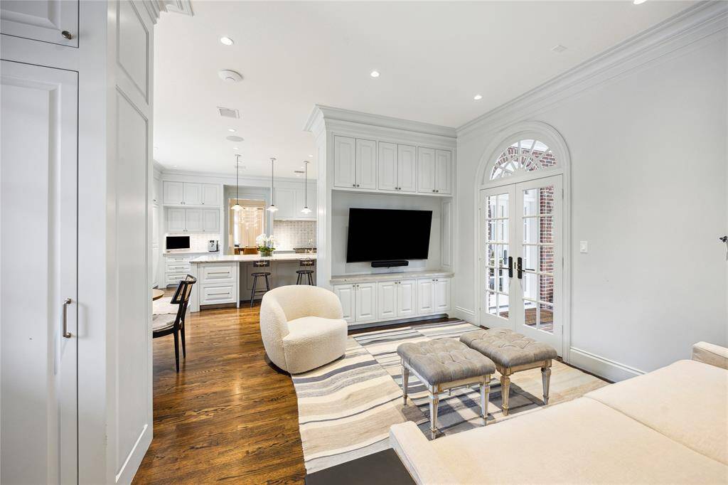 Seating Area off the Kitchen features built-in cabinetry with a mounted TV and French doors that open to the outdoors.