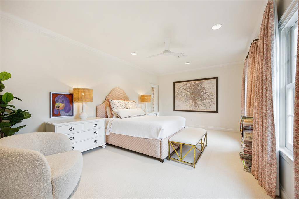 This serene Secondary Bedroom features soft tones, carpet installed in 2021, and a wall of windows with custom drapes.