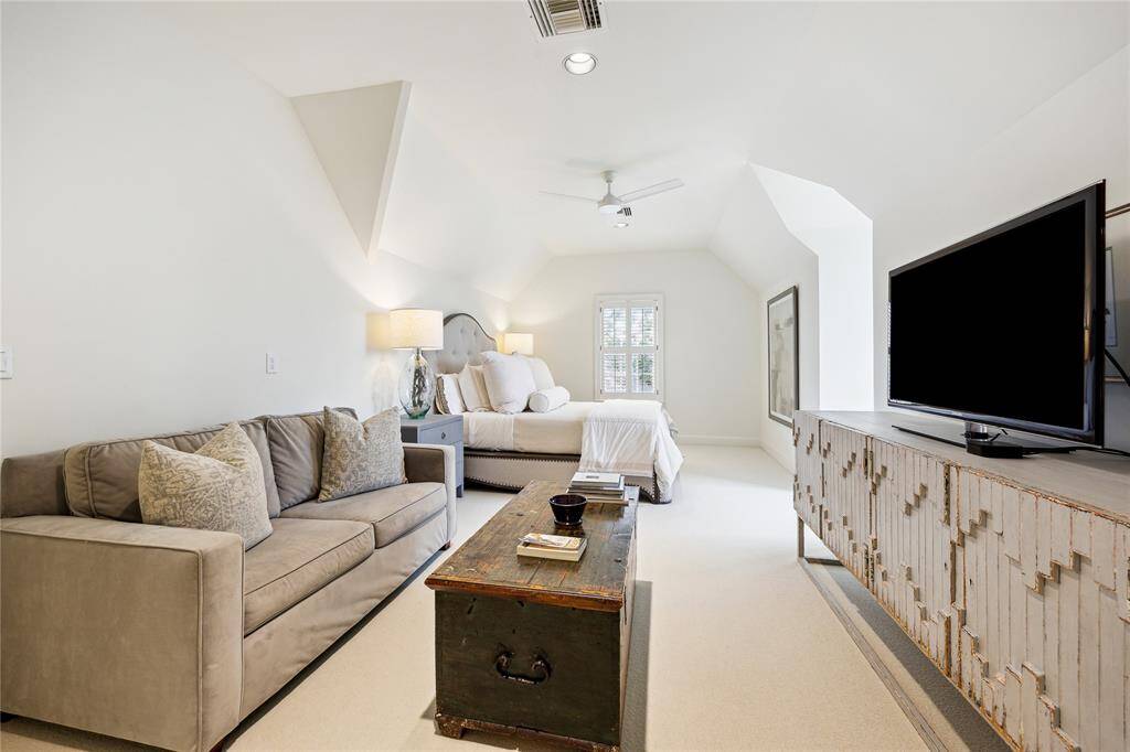 This spacious Third-Floor Bedroom features a neutral color palette, ample space for a seating area, and a walk-in cedar closet.