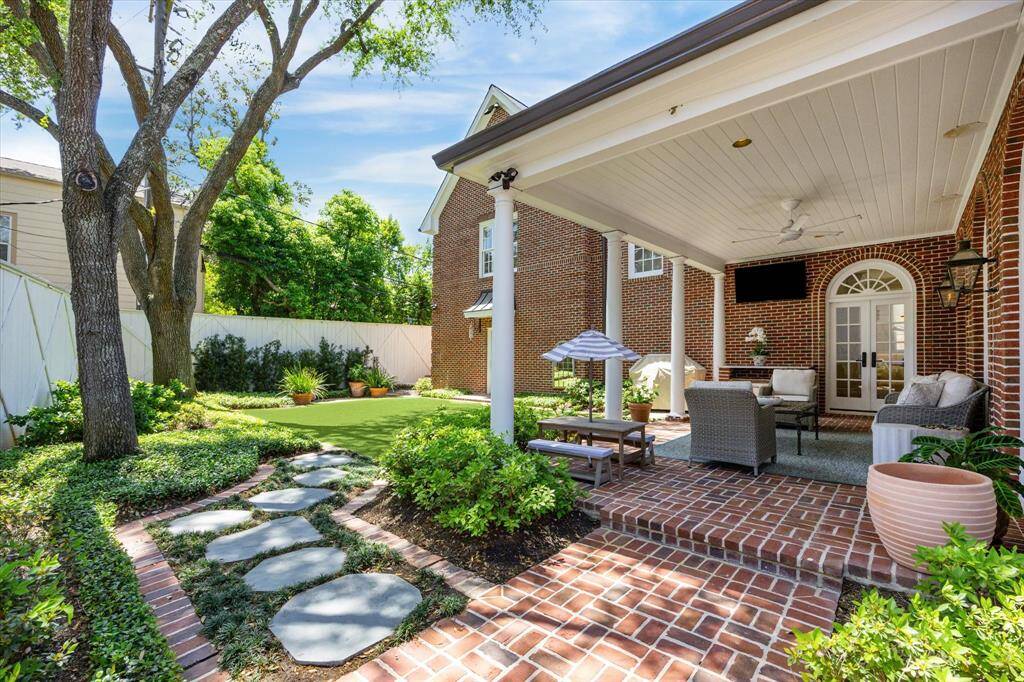 Another view of the covered porch and looking back onto the turfed yard.  Both the front and backyards have been extensively landscaped with mature plants and outdoor lighting.