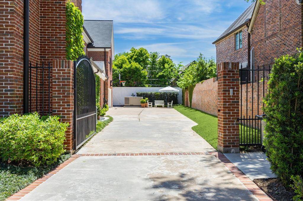 Tucked away behind elegant brickwork, this expansive driveway offers ample parking in addition to the two car garage. Perfect for basketball games and spacious enough to have an additional seating area.