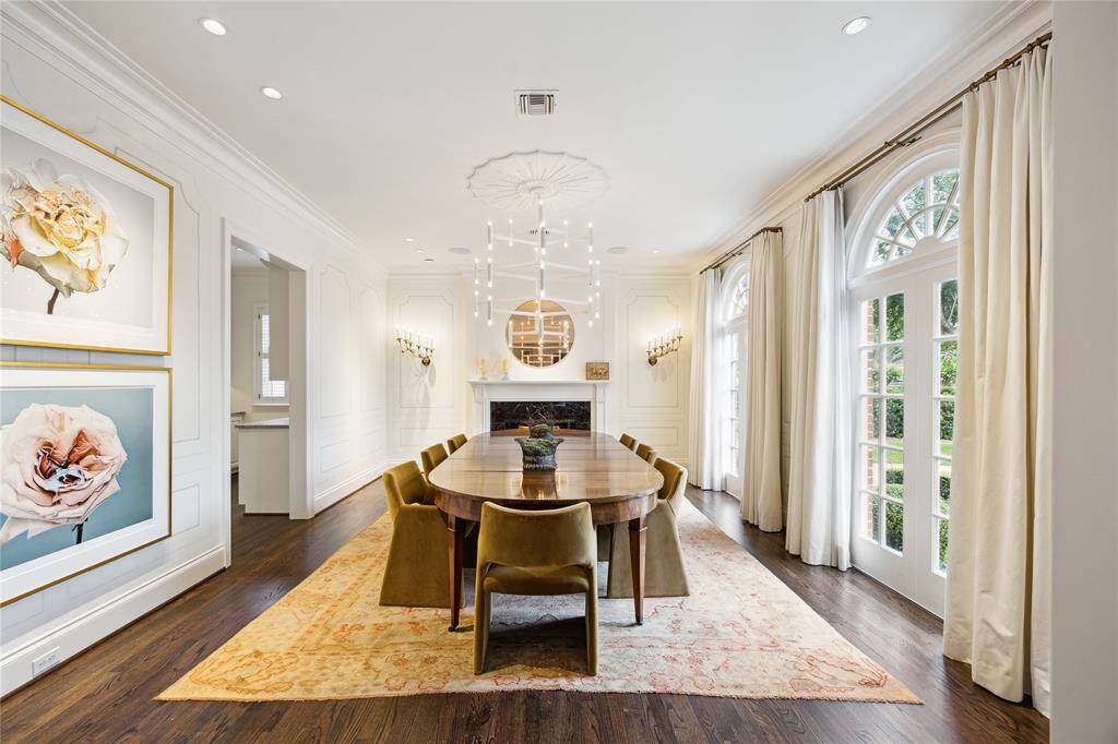 The beautiful Entry flows effortlessly into a modern Dining Room adorned with White on White Tromp L’Oeil paneled walls and a contemporary white plaster chandelier from Bourgeois Boheme.