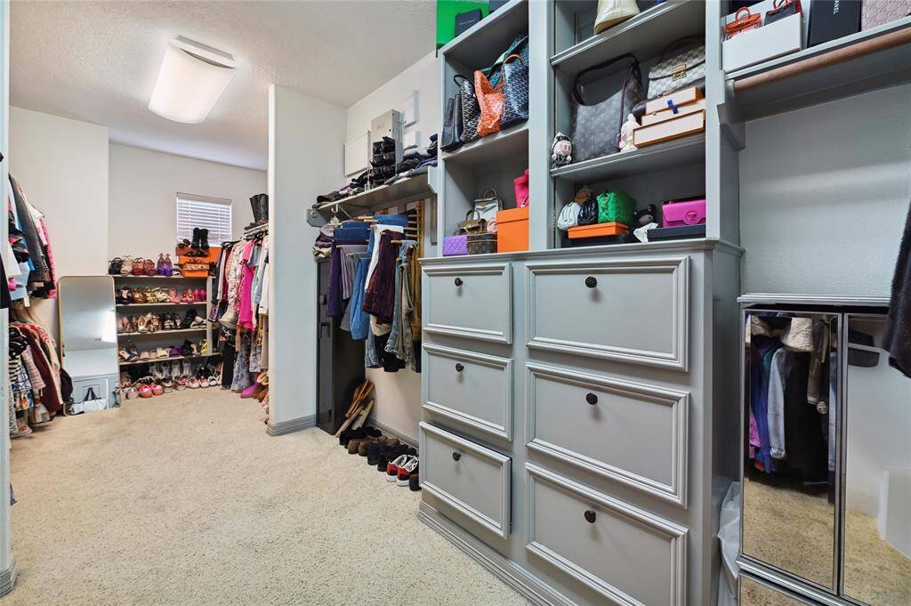 Amazing walk-in closet has plenty of storage and built-in drawers!
