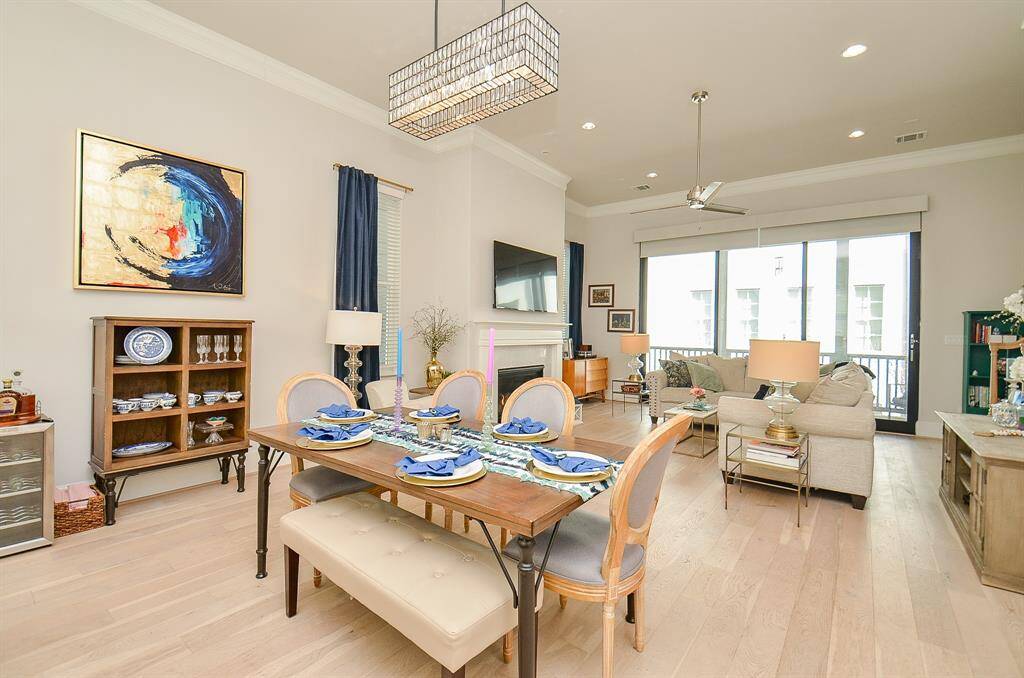 Desirable open floor plan is great for entertaining. Elegant chandelier in dining room and brushed gold curtain rods with blue drape panels.
