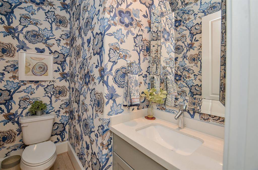 Beautifully custom wallpapered powder room with designer mirror on 2nd floor.