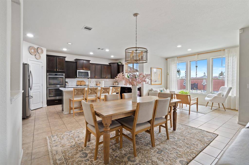 This dining room has tile floors and beautiful lighting.