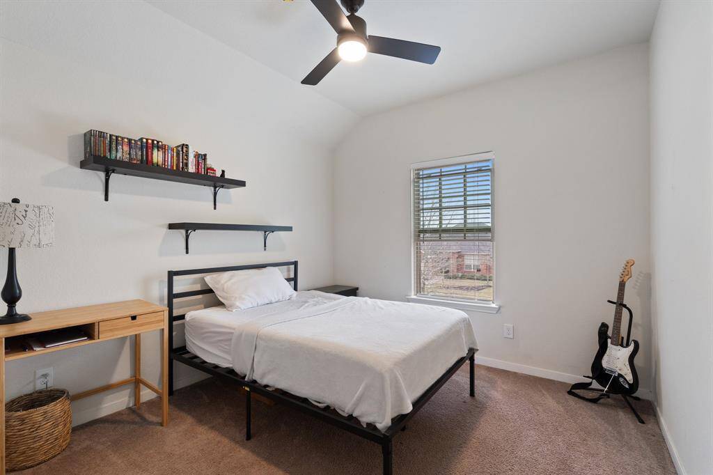 Secondary bedroom features awindow and plush carpet.
