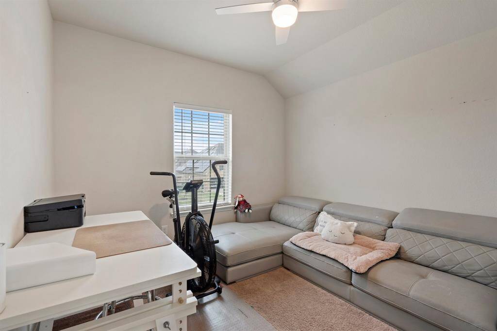 Fourth bedroom features awindow and plush carpet.