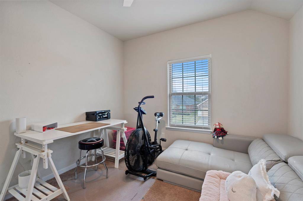 Fourth bedroom features awindow and plush carpet.
