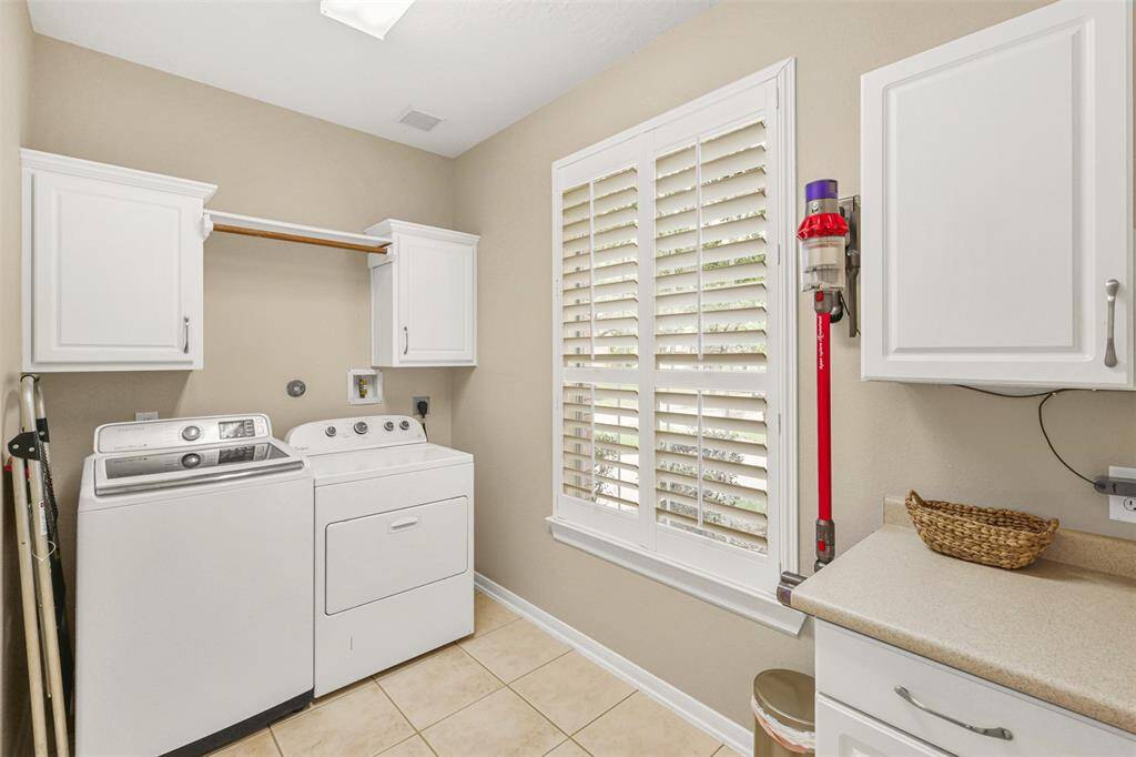 Large laundry room with space for storage.  Washer and dryer convey with home.