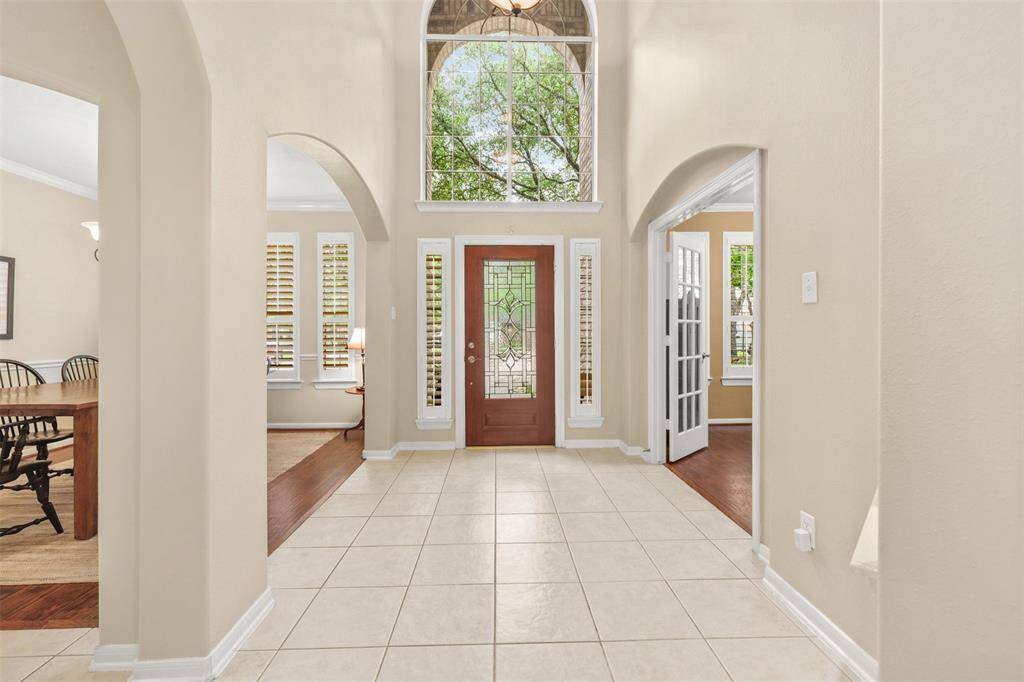 Sunlight streams through the second-story window, illuminating the open entryway welcoming you home.