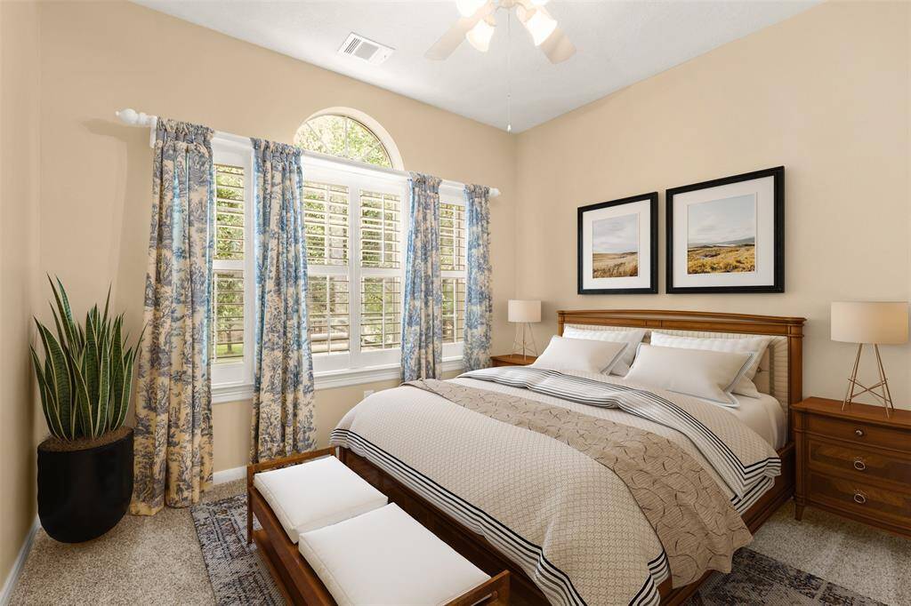 Upstairs bedroom with plantation shutters and ample natural light.  Photo virtually staged.