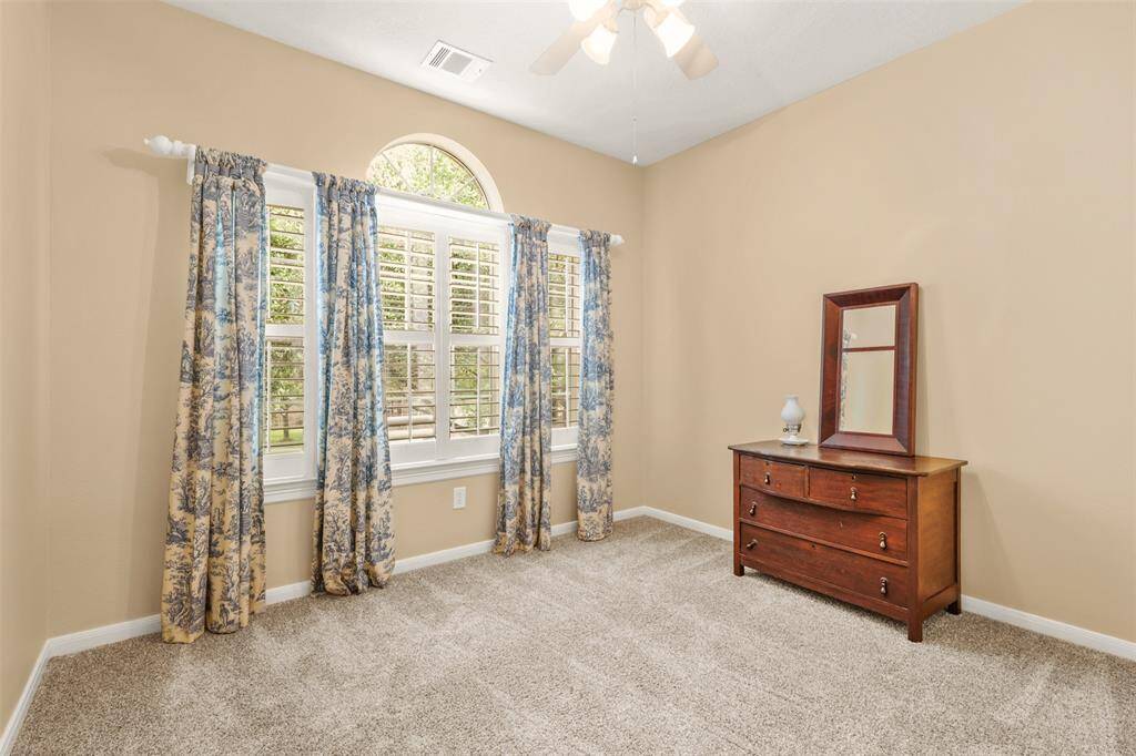 Upstairs bedroom with plantation shutters and ample natural light.