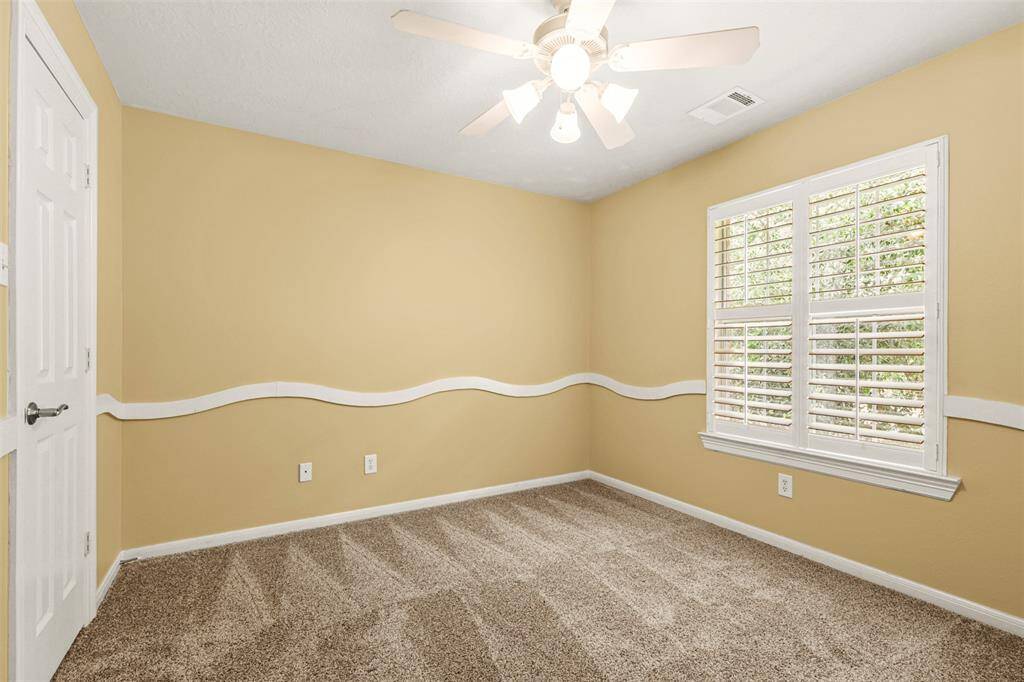Upstairs bedroom with fresh paint and plantation shutters.