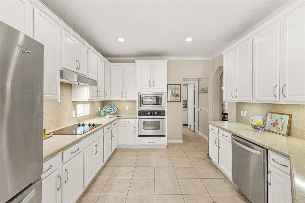 Under cabinet lighting enhances this light and bright kitchen which has been updated with a new dishwasher in 2022, as well as painted cabinets in 2023.