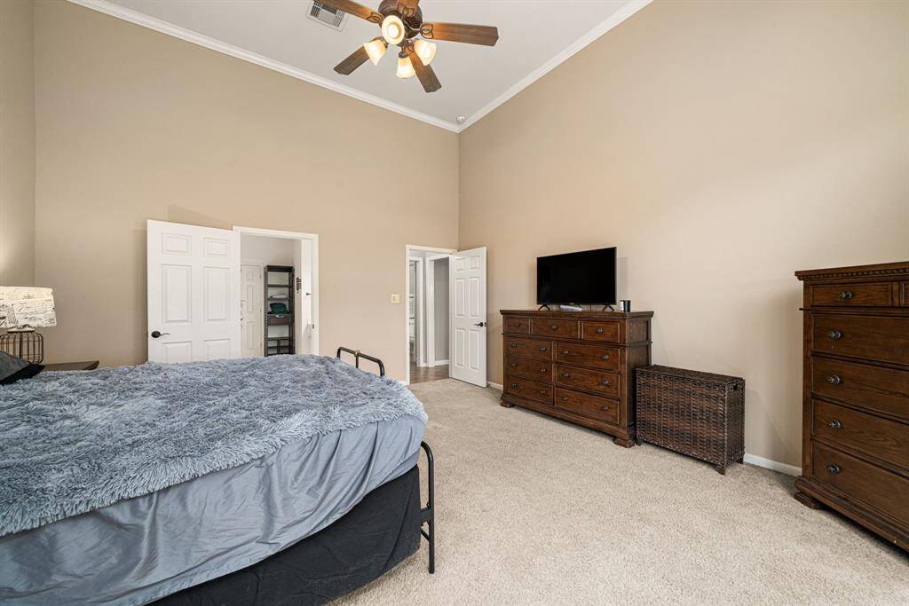 This expansive owner's retreat located on the first floor, features soaring ceilings and three sun-filled windows framing serene backyard views. The elegant ensuite bath offers dual vanities, a freestanding soaking tub, and a spacious walk-in shower, while the generously sized walk-in closet completes this private sanctuary.