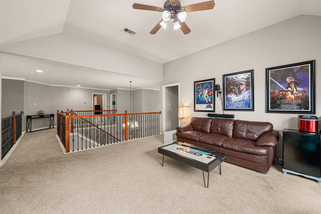 Across to the media room, this expansive flex space with high ceilings offers multiple layout possibilities for gaming, recreation, or alternative use. The room features: A panoramic overlook to the level below. Ample natural light from well-placed windows. A spacious storage closet for organizational convenienceIdeal for entertainment or adaptable living needs, this bright and functional area complements the home's thoughtful design.