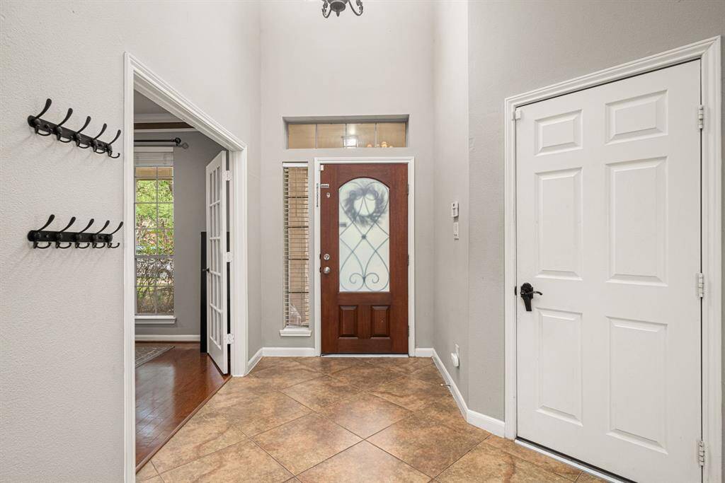 This home welcomes you with a striking two-story entryway featuring a beautiful custom front door. The thoughtfully designed layout places a private study to the right of the entrance, while convenient garage access is situated to the left, creating both impressive curb appeal and functional flow.