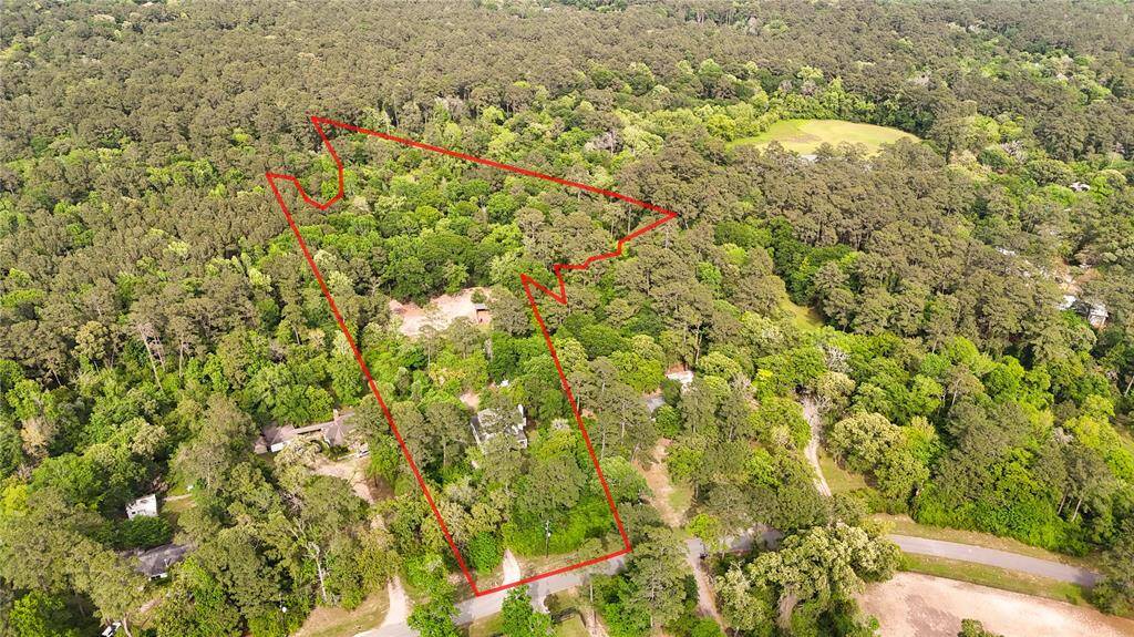 This aerial photo showcases a large, wooded property outlined in red, offering privacy and natural surroundings. Ideal for buyers seeking a secluded, nature-rich setting.