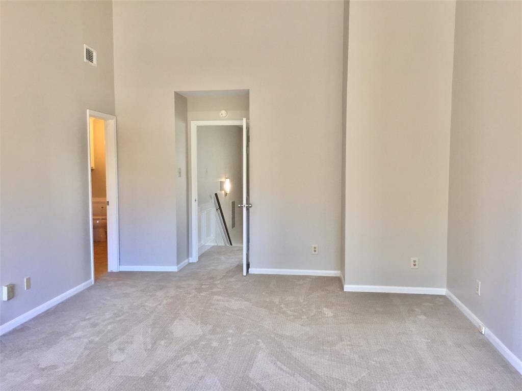 This is another view of the PRIMARY  BEDROOM SUITE.  The ceilings are approximately 18 ft high. and has lots of natural light from the private balcony.